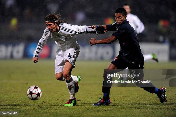 Sergio Ramos of Real Madrid is tackled by Michel Bastos of Lyon during the UEFA Champions League round of 16 first leg match between Lyon and Real...