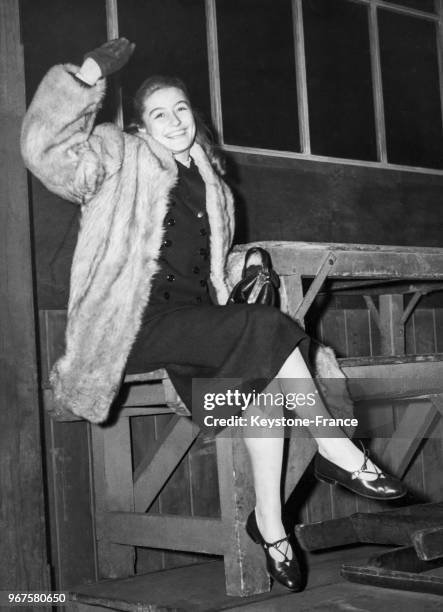 Anouk Aimée, âgée de 16 ans, salue gaiement à son arrivée à Victoria Station, à Londres, Royaume-Uni le 28 janvier 1949.