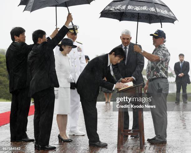 Japanese Prince Akishino , alongside his wife Princess Kiko , signs a guestbook after paying tribute at the National Memorial Cemetery of the Pacific...