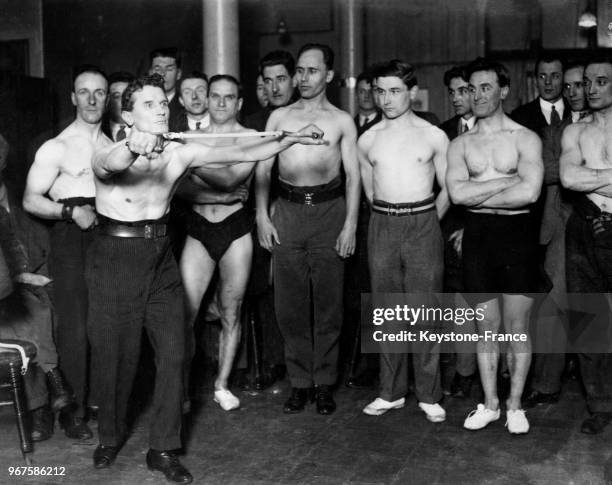 Alfred Banks, champion de culturisme à la retraite, fait une démonstration devant des concurrents, à Londres, Royaume-Uni le 21 janvier 1929.