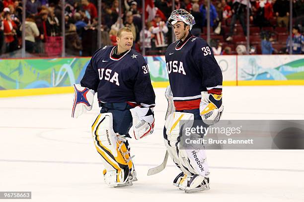 Goalies Tim Thomas and Ryan Miller of the United States skate off the ice after team USA won 3-1 against Switzerland during the ice hockey men's...
