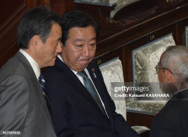 Japan's prime minister Yoshihiko Noda, second from left, and vice premier Katsuya Okada, left, talk with his party member before a lower house...