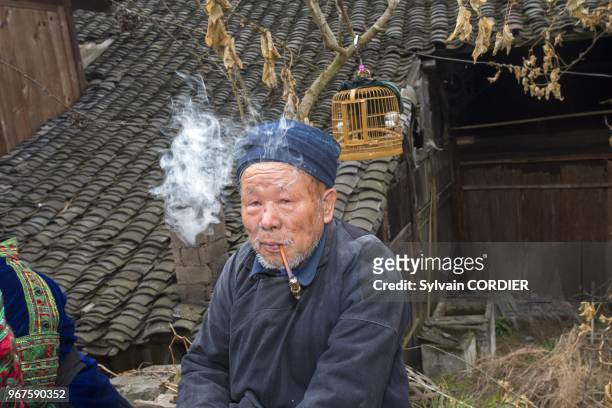 Chine, province du Guizhou, village de Langde, ethnie des Long Skirt Miao en habits traditionnels, les hommes fument. China, Guizhou province, Langde...