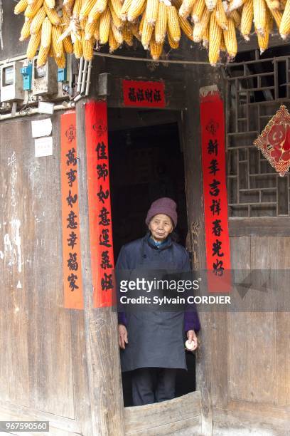 Chine, province du Guizhou, village de Shiqiao, ethnie des Hans, vieille femme a l'entree de la porte de sa maison. China, Guizhou province, Shiqiao...