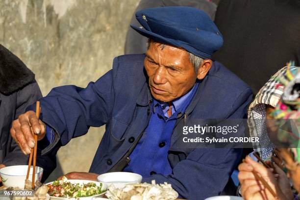 Chine , Province du Yunnan , Ethnie des Yi, Yuanyang, village de Mengpin, banquet general du village dans les rues, Vieil homme a table.