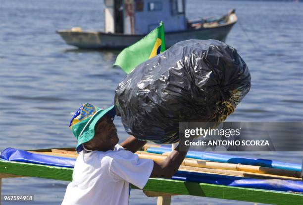 Brazilian fisherman Bira loads his boat with plastic garbage removed from Catalao Beach, inside the Guanabara bay, May 6 in Rio de Janeiro, Brazil....