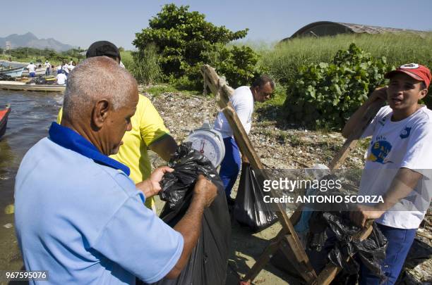 Brazilian fisherman weights part of the plastic garbage removed from Catalao Beach, inside the Guanabara bay, May 6 in Rio de Janeiro, Brazil. Some...