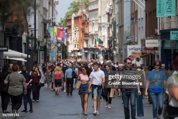 Shoppers walk passed shops on Grafton Street in Dublin, Ireland, on Monday, June 4, 2018. Companies are expanding in Dublin rather than the U.K. In a...