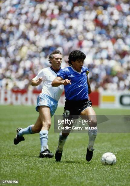 Diego Maradona of Argentina runs with the ball passed Peter Reid of England during the 1986 FIFA World Cup Quarter Final on 22 June 1986 at the...