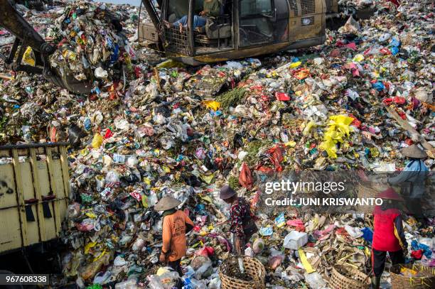 Scavengers collect valuable waste at Sidoarjo garbage dump in East Java, on June 5, 2018. - About eight million tonnes of plastic waste are dumped...