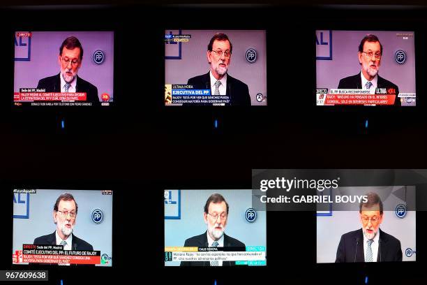 Former prime minister Mariano Rajoy is seen on TV screens during a press conference following a People's Party meeting of the national executive...