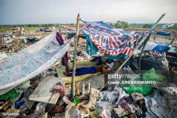 Scavenger takes a nap at Sidoarjo garbage dump in East Java, on June 5, 2018. - About eight million tonnes of plastic waste are dumped into the...