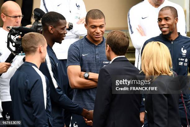 French President Emmanuel Macron speaks with France's forward Kylian Mbappe , France's midfielder Paul Pogba and France's foward Antoine Griezmann as...