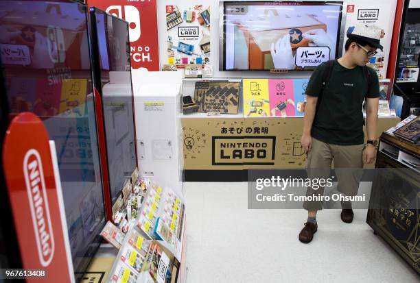 Customer walks in front of the Nintendo Labo cardboard construction set for the Switch console displayed for sale at the Bic Camera Yurakucho...