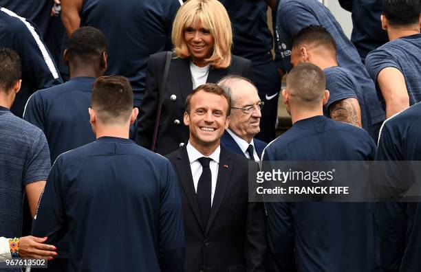 French President Emmanuel Macron reacts as he and his wife Brigitte Macron visit France's national football team players in...