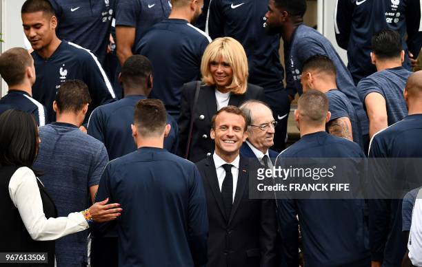 French President Emmanuel Macron reacts as he and his wife Brigitte Macron visit France's national football team players in...