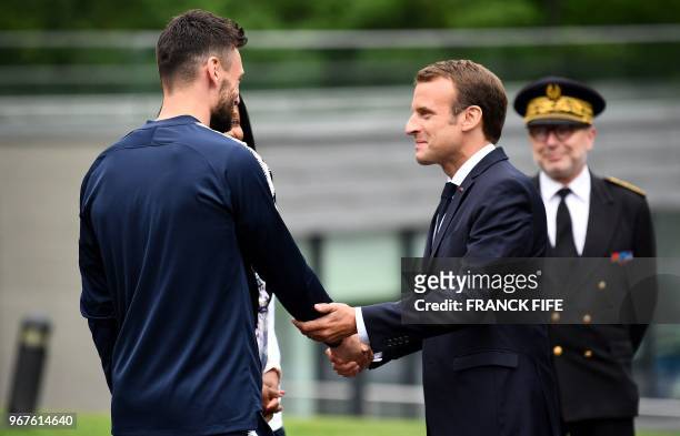 French President Emmanuel Macron speaks with France's goalkeeper Hugo Lloris as he visits France's national football team players in...