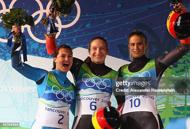 Nina Reithmayer of Austria celebrates winning silver, Tatjana Huefner of Germany gold and Natalie Geisenberger of Germany bronze during the flower...