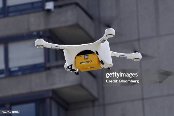 An M2 delivery drone, manufactured by Matternet Inc., carries a Swiss Post International Holding AG branded box containing laboratory samples, as it...