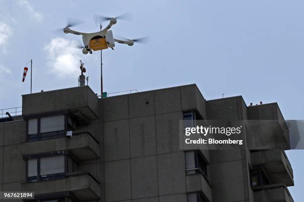 An M2 delivery drone, manufactured by Matternet Inc., carries a Swiss Post International Holding AG branded box containing laboratory samples, as it...
