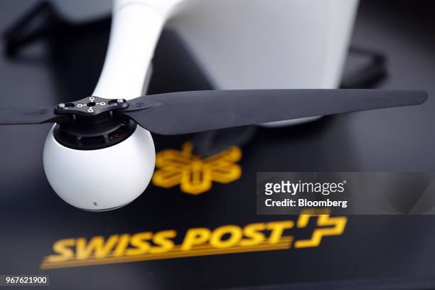 Blade of an M2 delivery drone, manufactured by Matternet Inc., sits on a landing pad in front of a Swiss Post International Holding AG logo, as it...