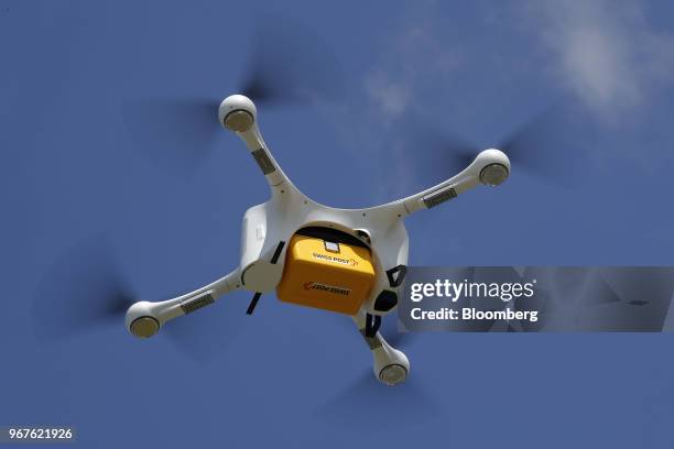 An M2 delivery drone, manufactured by Matternet Inc., carries a Swiss Post International Holding AG branded box containing laboratory samples, as it...