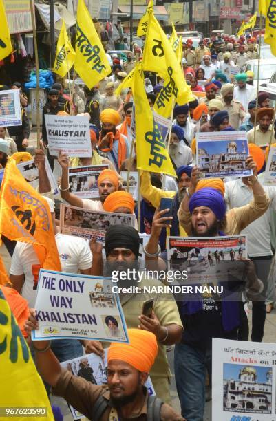 Shiromani Akali Dal activists hold flags and placards during a protest march on the eve of 34th Operation Blue Star anniversary in Amritsar on June...