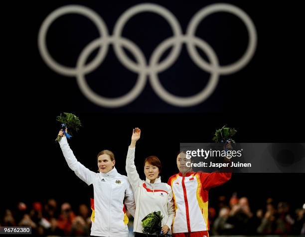 Jenny Wolf of Germany poses after winning the silver, Lee Sang-Hwa of South Korea the gold and Wang Beixing of China the bronze medal during the...