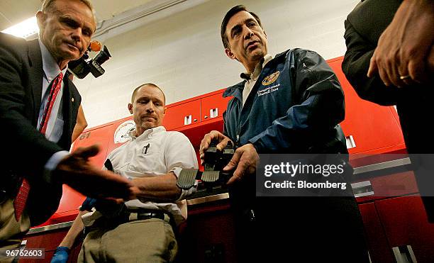 Representative Darrell Issa, center right, looks over a gas pedal with Shop Manager John Krause, center left, and U.S. Representative Brian Bilbray,...