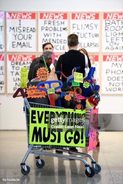 Shopping trolley filled with plastic goods, titled "Closing Down Sale" by Michael Landy is seen during a press preview of the 250th Summer Exhibition...