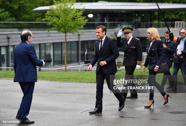 French President Emmanuel Macron and his wife Brigitte Macron arrive to visit at France football national team's training camp in...