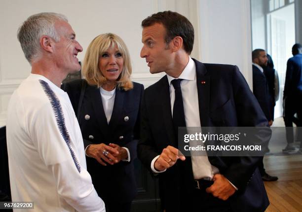 French President Emmanuel Macron speaks to the French football national team's head coach Didier Deschamps as his wife, Brigitte Macron looks on...