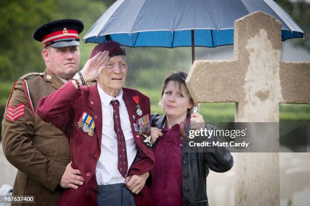 Ray Shuck who was a paratrooper on D-Day and was later shot in the head by a German sniper salutes a memorial cross that commemorates his fallen...