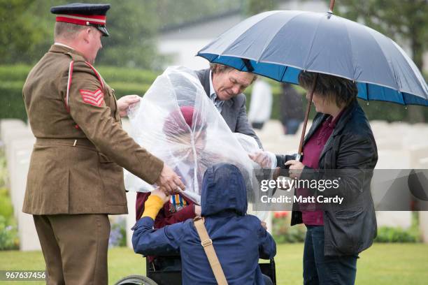 Ray Shuck who was a paratrooper on D-Day puts on a poncho as he visits the cemetery in Ranville in Normandy on June 5, 2018 in Ranville, France. Ray...