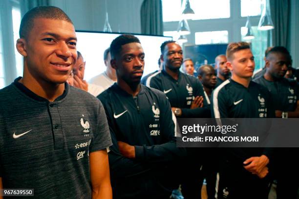 French football team's foward Kylian Mbappe listens with teammates at French President during his visit at France's training camp in...