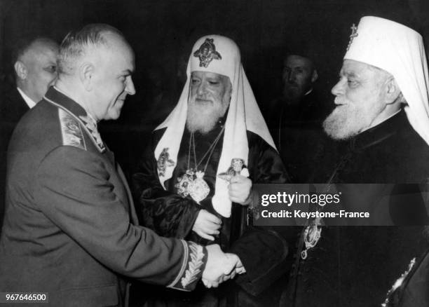 Le maréchal Joukov serre la main du patriarche de Serbie Vincent, à droite le patriarche russe Alexis II, à Belgrade, Yougoslavie le 20 octobre 1957.