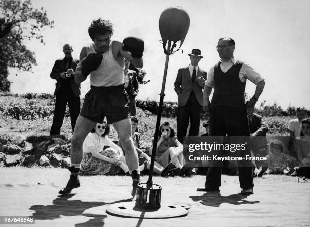 Le boxeur Freddie Mills s'entraîne sur un punching-ball en plein air le 20 juillet 1948 à Dorking, Royaume-Uni.