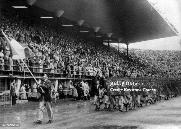 équipe française défile dans le stade avec en tête Heinrich portant le drapeau français le 20 juillet 1952 à Helsinki, Finlande.