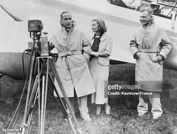 Aviateur britannique Tom Campbell Black pose en compagnie de sa femme l'actrice Florence Desmond et de son copilote Mac Arthur près de son avion...