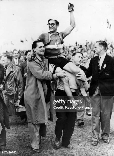 Le Français José Beyaert, médaille d'or de la course en ligne est porté par ses compatriotes après sa victoire, à Windosr, Royaume-Uni le 13 août...