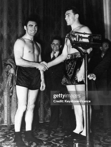 Les boxeurs Max Schmeling et Steve Dudas se serrent la main après la pesée avant un match le 16 avril 1938 à Hambourg, Allemagne.