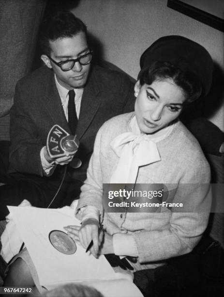 La cantatrice Maria Callas avec un journaliste à l'aéroport de Frankfort, Allemagne le 14 mai 1959.