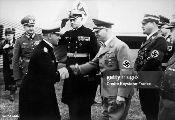 Amiral Räder en visite au port serre la main du commandant Mutschmann, entouré du Général Mehnert, de Zimmermann, de Schepman et du commandant de...