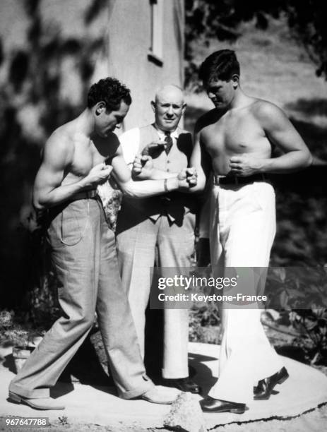 Le boxeur américain Max Baer et son petit frère Buddy se mesurent sous l'oeil attentif de leur père le 19 juillet 1933 à Oakland, CA.