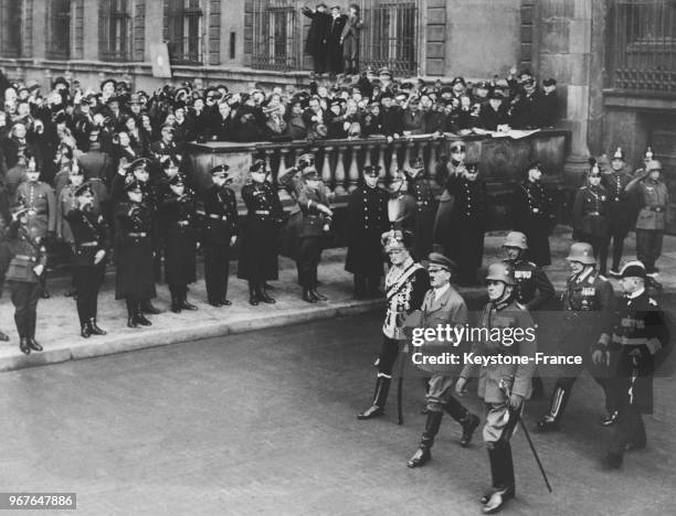 Hitler passent les troupes en revue, à sa droite le maréchal von Mackensen, à sa gauche le général von Fritsch et derrière le général Goering et...