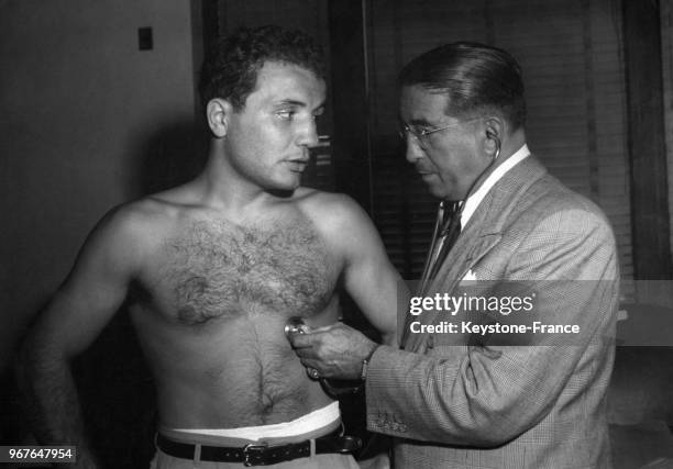 Le boxeur Jake LaMotta examiné par le médecin de la Fédération de boxe de New York avant son match, à New York City, Etats-Unis le 26 juin 1949.