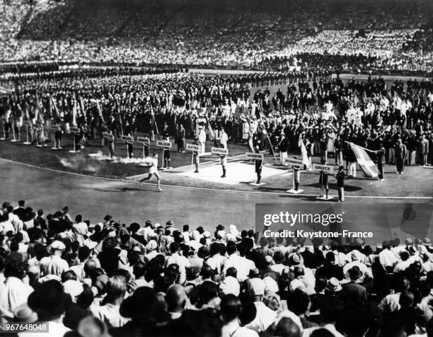 Athlète John Mark porte la flamme olympique pour un tour d'honneur du stade de Wembley lors de la cérémonie d'ouverture des Jeux Olympiques le 29...