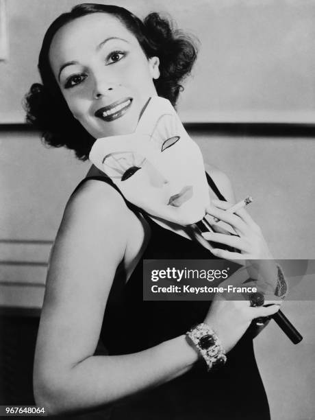 Actrice Dolores del Rio tient dans ses mains un masque blanc qui reproduit ses propres traits, à Hollywood, Californie, Etats-Unis le 22 novembre...