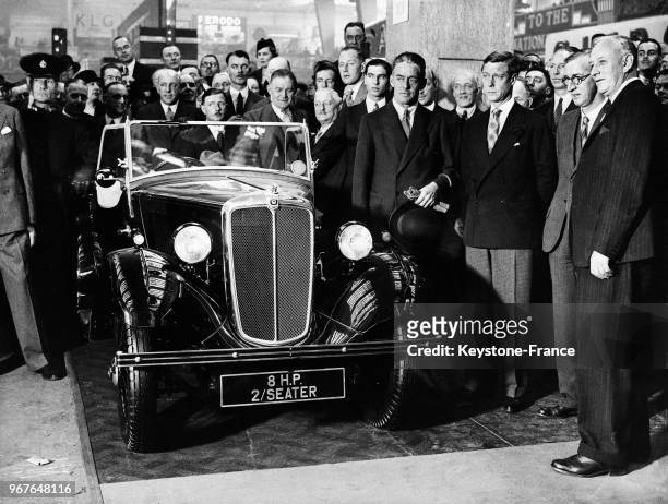 Pendant sa visite inaugurale, le prince de Galles s'arrête à un stand devant une des voitures les moins chères du monde, à sa droite, le 1er vicomte...