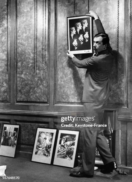 Cecil Beaton accrochant une photographie pour son expostion de photographies et peintures à la Cooling's Gallery à Londres, Royaume-Uni, le 24...